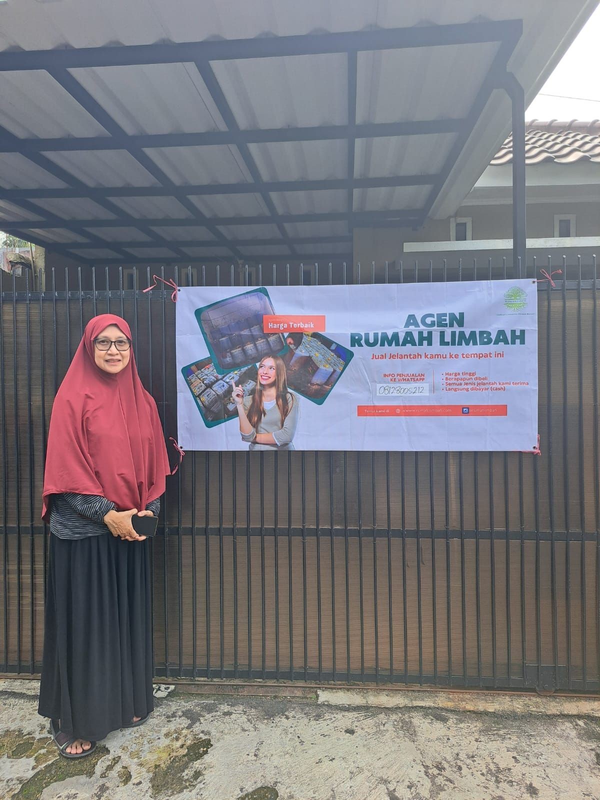 Woman standing next to a fence with a banner promoting waste management services.